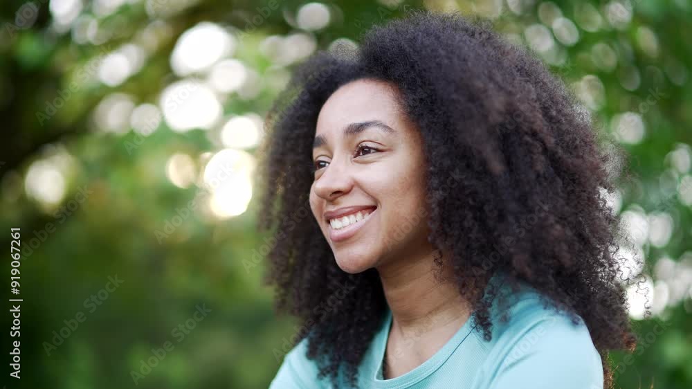 Peaceful young african american sportswoman relaxing with closed eyes in urban city park. A smiling calm beautiful fit black woman breathes deeply, feels relief and enjoys being in nature. Close up Peaceful young african american sportswoman relaxing with closed eyes in urban city park. A smiling calm beautiful fit black woman breathes deeply, feels relief and enjoys being in nature. Close up