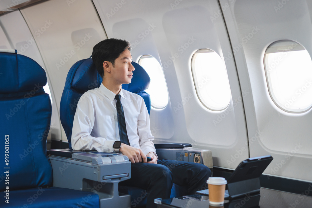 Successful business man, Airplane, travel, enjoying comfortable flight while sitting in the airplane cabin. Successful business man, Airplane, travel, enjoying comfortable flight while sitting in the airplane cabin.