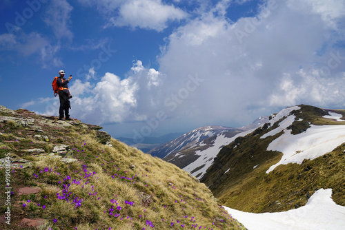 Mountaineer trekking on the beautiful mountain with camera making photo.