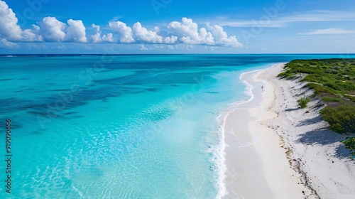 Aerial view of a pristine beach with turquoise waters and white sand