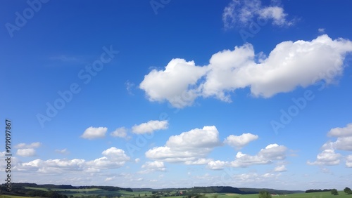 Peaceful Countryside Under Expansive Blue Sky with Serene White Clouds