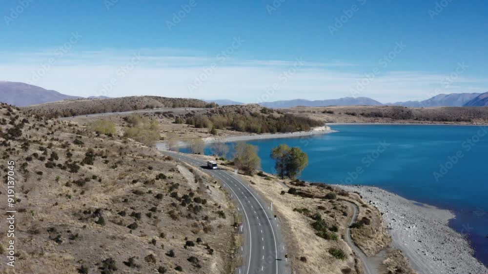 A bus drives around bend next to Lake Pukaki, South Island New Zealand. Drone A bus drives around bend next to Lake Pukaki, South Island New Zealand. Drone