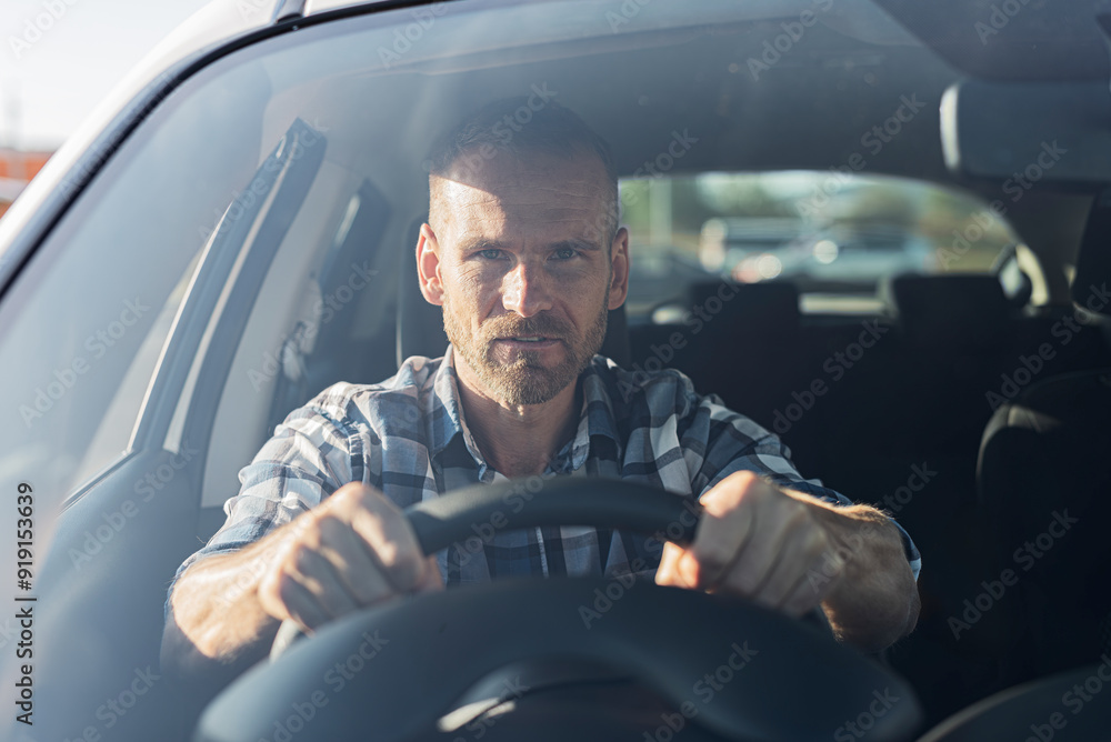 The driver is a young attractive man driving a white car.