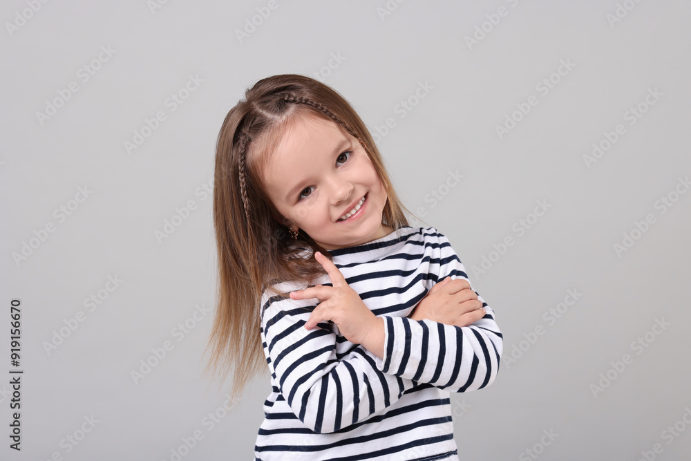 Portrait of happy little girl on grey background Portrait of happy little girl on grey background
