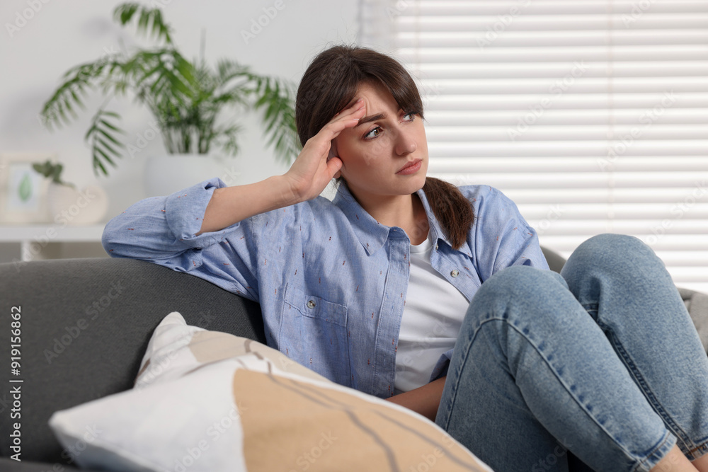 Loneliness concept. Sad woman sitting on sofa at home Loneliness concept. Sad woman sitting on sofa at home