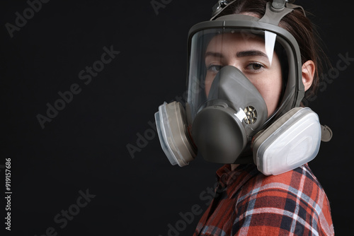 Fotografie Woman in respirator mask on black background, space for text