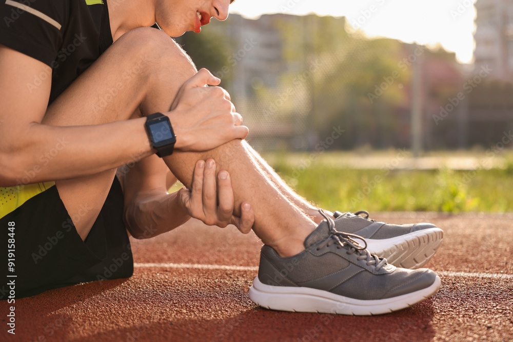 Sportsman with leg injury at stadium, closeup Sportsman with leg injury at stadium, closeup