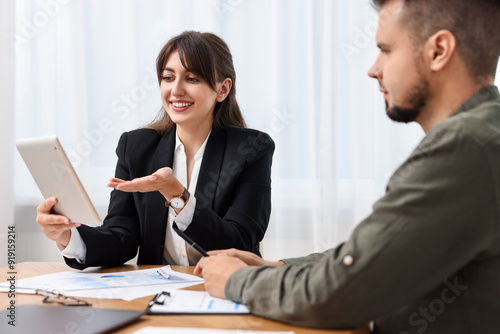 Wallpaper Mural Smiling consultant working with client at table in office. Business meeting Torontodigital.ca