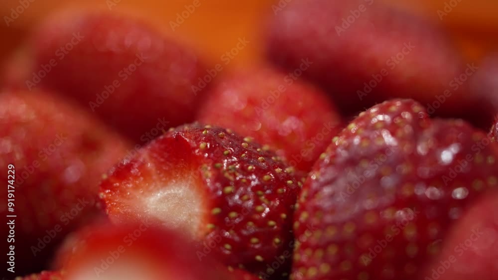 Close up view of whole juicy red strawberries with green leaves cut off being processed at a factory Close up view of whole juicy red strawberries with green leaves cut off being processed at a factory