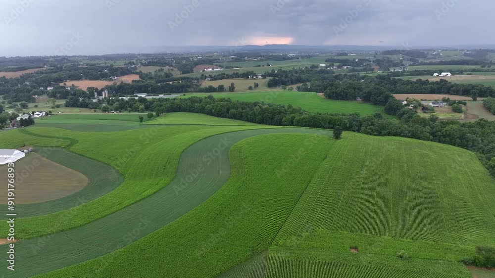 Aerial view of rural landscape with agriculture fields on hill during cloudy day in USA. Thunderstorm and dense clouds at sky at horizon. Aerial view of rural landscape with agriculture fields on hill during cloudy day in USA. Thunderstorm and dense clouds at sky at horizon.