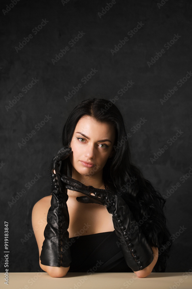 Fototapeta premium Beautiful dark-haired woman in black long gloves