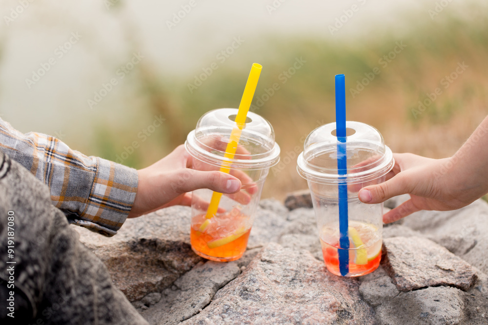 Two drink bubble tea in children's hands, close-up Two drink bubble tea in children's hands, close-up