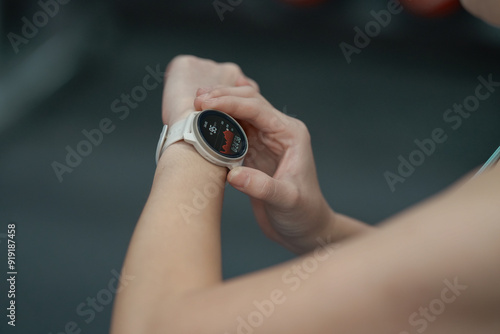 Young woman workout in gym using smart watch and application.