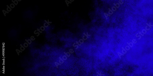 Blue color powder explosion cloud on black background. Closeup of Blue dust particles exhale on dark background.  Black,blue abstract background. Navy blue grunge texture.