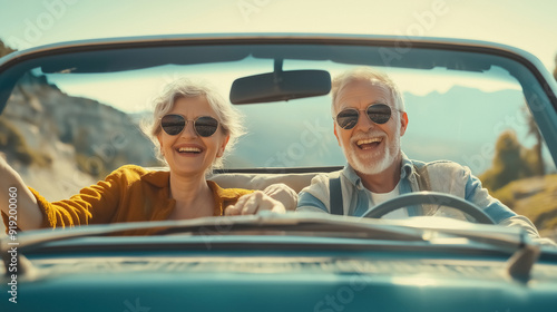 A joyful senior couple during a road trip. They are happily seated in their car, with a picturesque view of the open road and countryside behind them