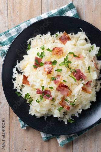 Slovak potato dumplings halusky with steamed sauerkraut and bacon on wooden table photo