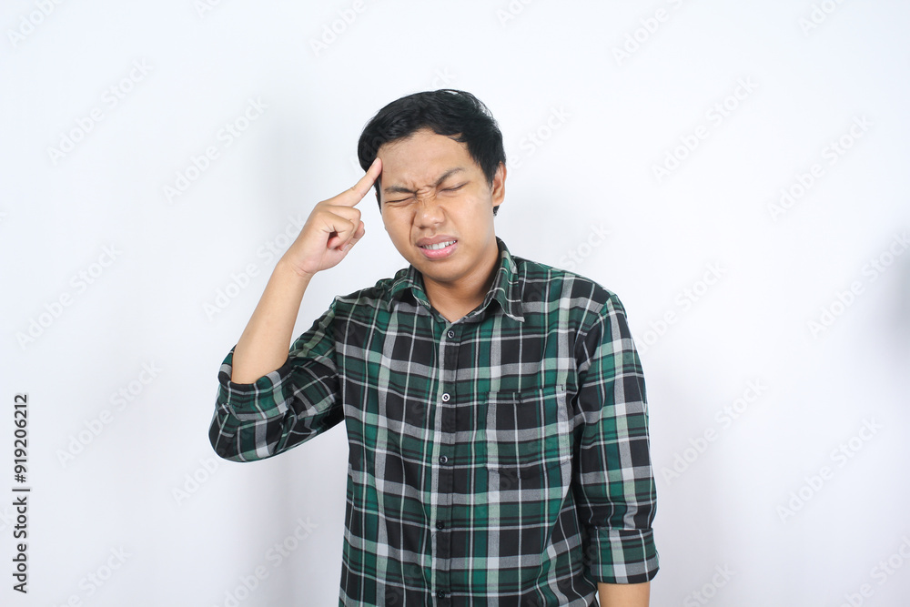 handsome asian man suffering from migraine and touching his head feeling sick and unwell isolated handsome asian man suffering from migraine and touching his head feeling sick and unwell isolated