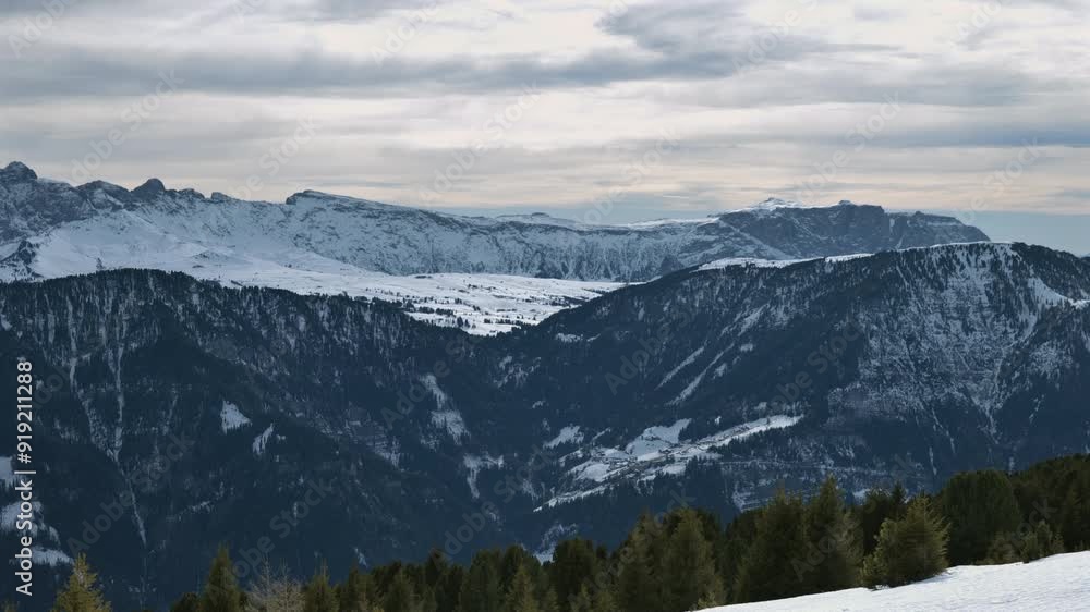 custom made wallpaper toronto digitalExpansive view of a snowy mountain range with forested hills and a cloudy sky.