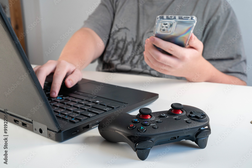 dłonie osoby korzystającej z telefonu, komputera, gamepada