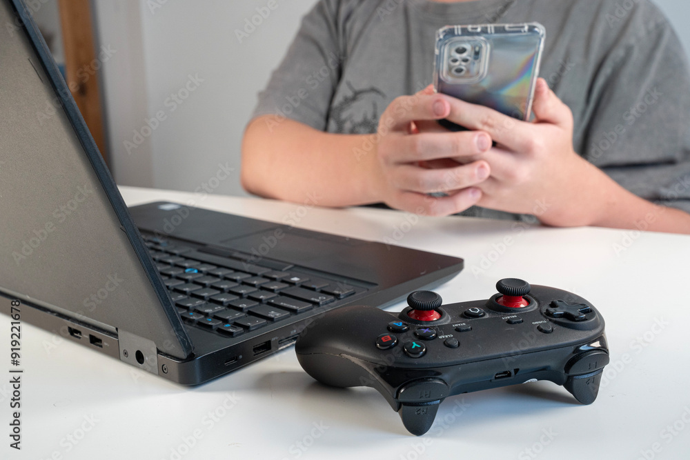 dłonie osoby korzystającej z telefonu, komputera, gamepada