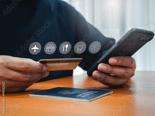 Foto Travel payment plan, icon on credit card in businessman hand while using smart mobile phone to purchase on app for flight and hotel booking and passport on wooden table