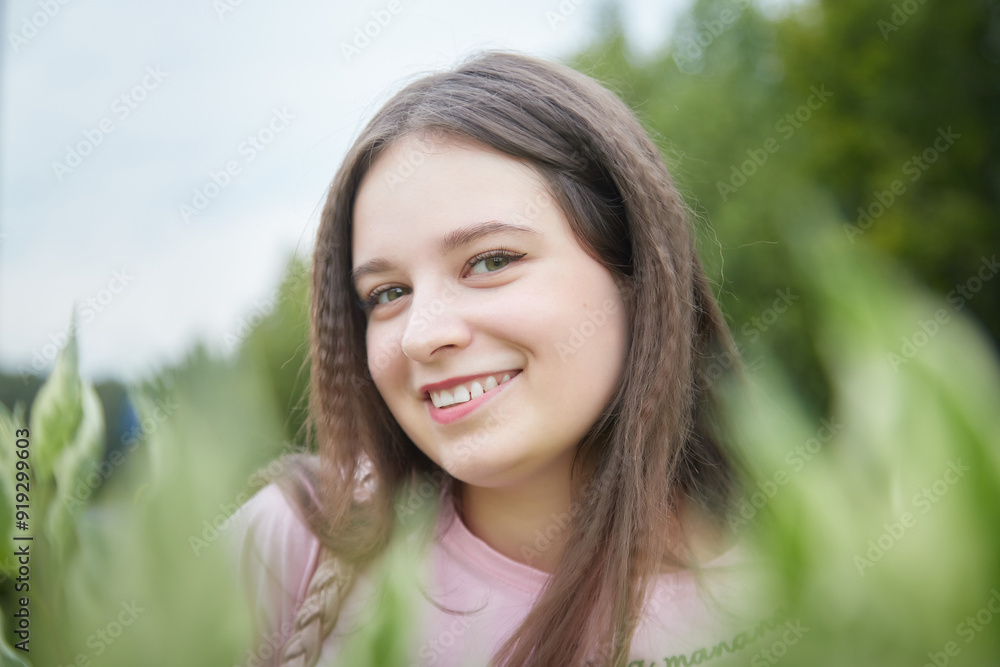Portrait of young pretty woman with long brown hair in greenery Portrait of young pretty woman with long brown hair in greenery