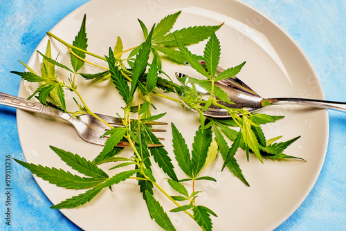 Bilde på lerret natural still life with hemp branches on a plate and forks on a blue background,