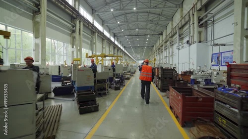 This is a scene depicting a manufacturing floor bustling with workers in an industrial setting. Stock Clip photo