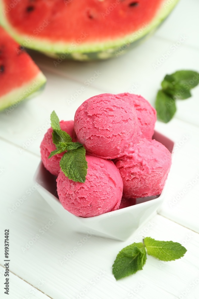 Scoops of tasty watermelon sorbet with mint in bowl on white wooden table Scoops of tasty watermelon sorbet with mint in bowl on white wooden table