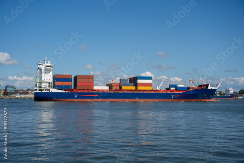 Containerised cargo ship against a blue sky photo