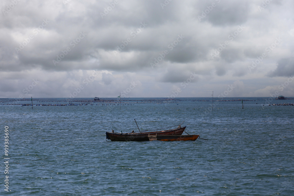A fishing boat floats in the middle of the sea.. A fishing boat floats in the middle of the sea..
