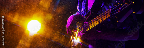 Banner. Musician's hand strums guitar, highlighted by electric blue and purple lights, creating vivid scene of musical passion. Concept of music and party, hobby and work, energy, music festivals. Ad photo