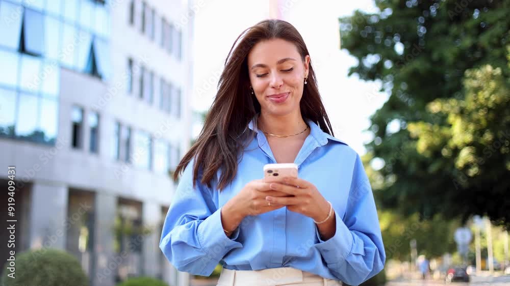 Beautiful woman smiling and using smartphone on the street Beautiful woman smiling and using smartphone on the street