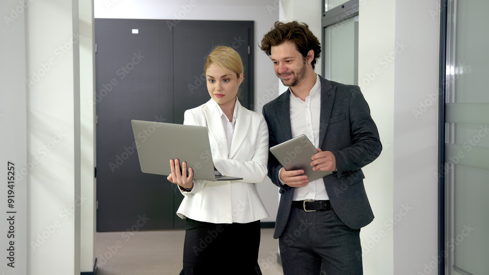 A director and a senior colleague review online business services and corporate software together on a laptop. Ideal for themes of leadership, teamwork, and technology consultation in the office. A director and a senior colleague review online business services and corporate software together on a laptop. Ideal for themes of leadership, teamwork, and technology consultation in the office.