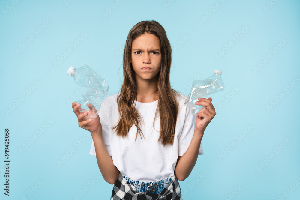 Sad angry disappointed caucasian teenager schoolgirl student pupil eco-activist holding plastic bottles for anti-pollution and environment protection isolated in blue background Sad angry disappointed caucasian teenager schoolgirl student pupil eco-activist holding plastic bottles for anti-pollution and environment protection isolated in blue background