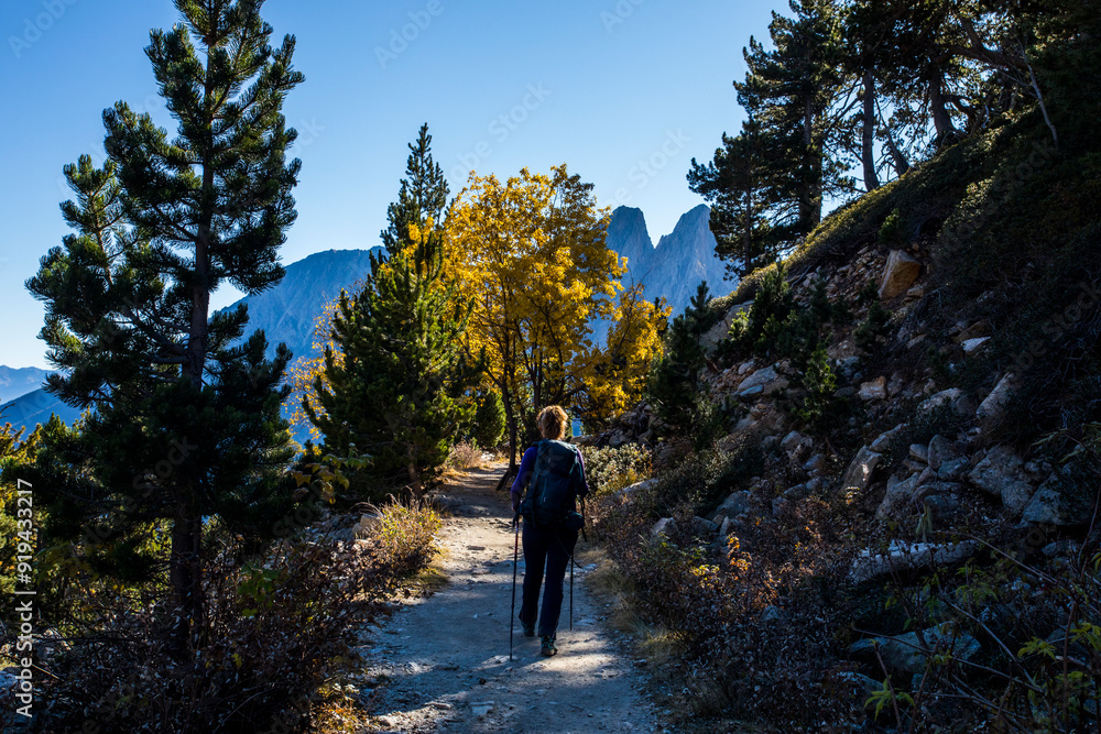 Fototapeta premium Young hiker woman in autumn in Aiguestortes and Sant Maurici National Park, Spain
