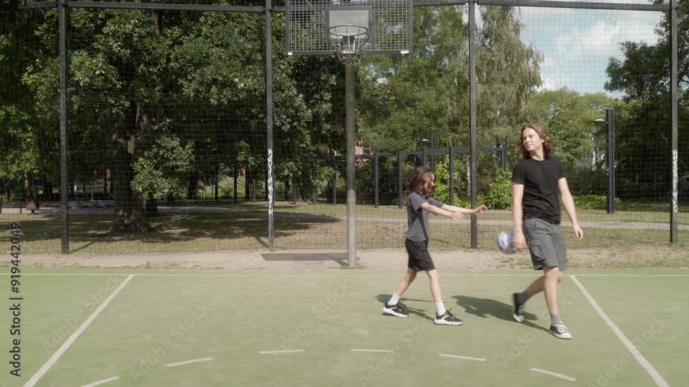 Friends alternate shots at the basketball hoop, mixing success and failure. The ball rebounds off the rim as they keep practicing, balancing fun with effort and the challenge of improvement. Friends alternate shots at the basketball hoop, mixing success and failure. The ball rebounds off the rim as they keep practicing, balancing fun with effort and the challenge of improvement.