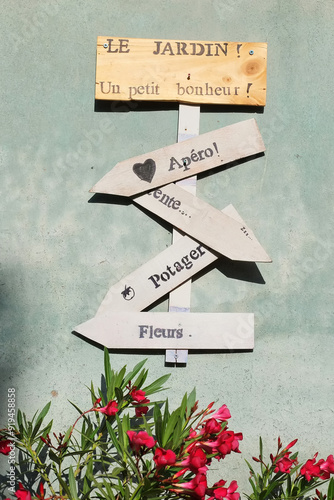 Le Jardin! Un petit bohneur! cozy french yard decorated with lettering. French signs on wooden planches for cozy yard.