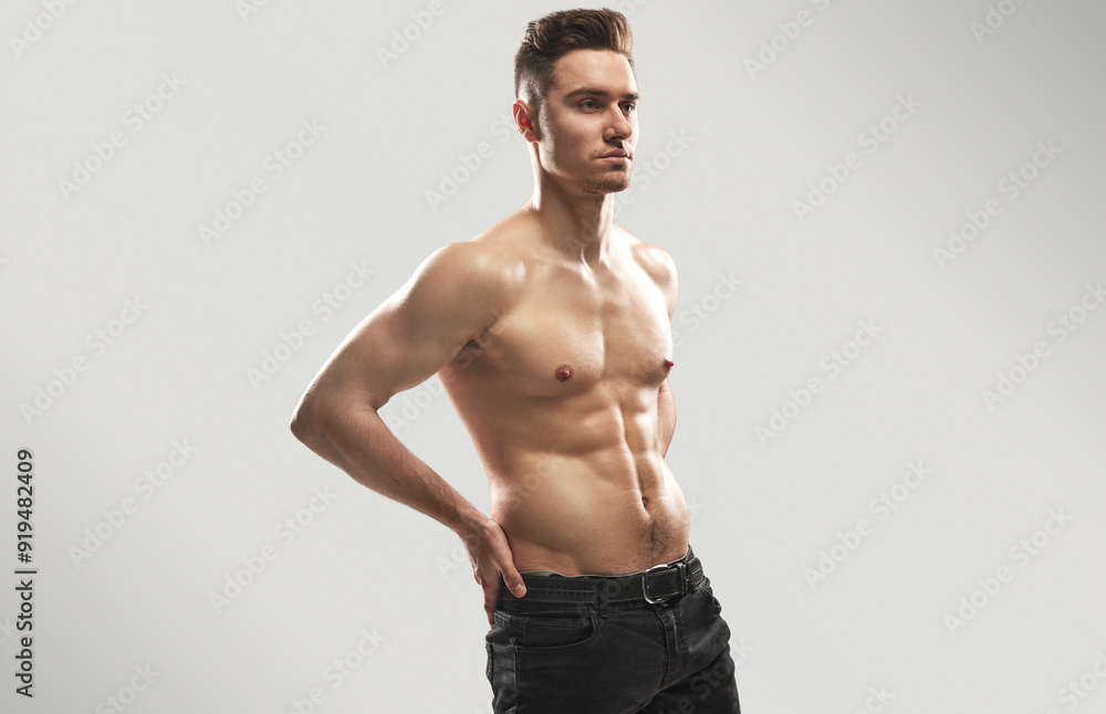 A muscular man posing confidently in a studio setting, showcasing a fit and athletic physique. Ideal image for fitness, health, and lifestyle concepts. A muscular man posing confidently in a studio setting, showcasing a fit and athletic physique. Ideal image for fitness, health, and lifestyle concepts.