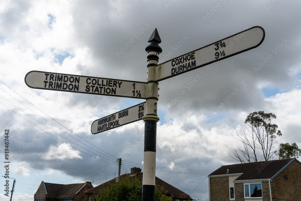 Fototapeta premium Trimdon, County Durham, UK. Signpost in the village showing distances to other places nearby,