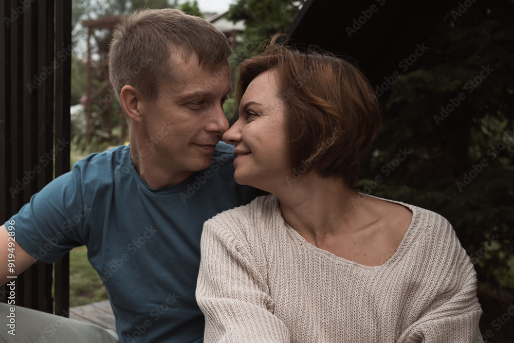 mid adult couple in love before kiss sitting outdoors in backyard in summer mid adult couple in love before kiss sitting outdoors in backyard in summer