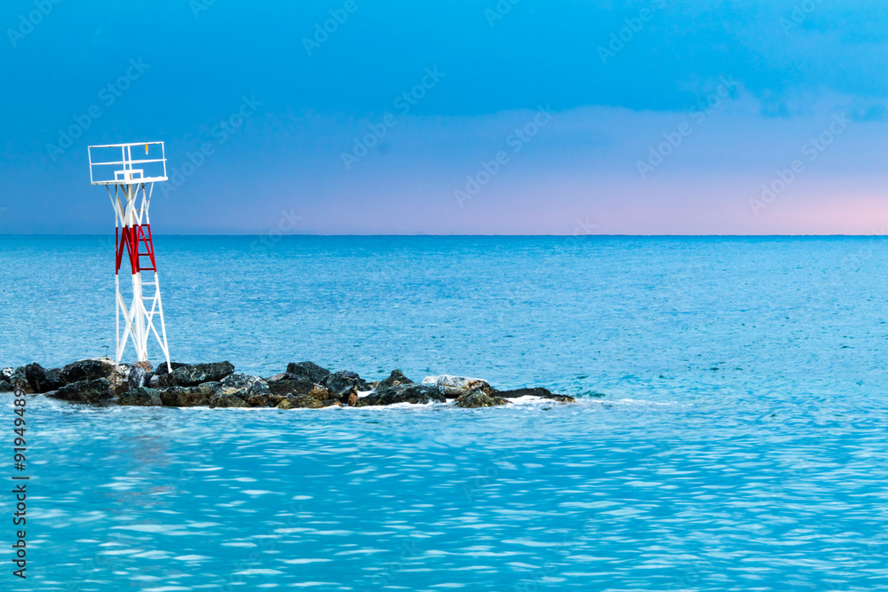 Fototapeta premium A small lighthouse on a stone embankment in Platamon, Greece