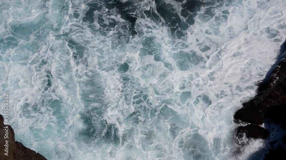 Sea water surface. Turquoise blue water with white foam on waves - view from above. Aerial high quality 4K video. Stylized background abstract texture. Tenerife, Puerto de la Cruz. Sea water surface. Turquoise blue water with white foam on waves - view from above. Aerial high quality 4K video. Stylized background abstract texture. Tenerife, Puerto de la Cruz.
