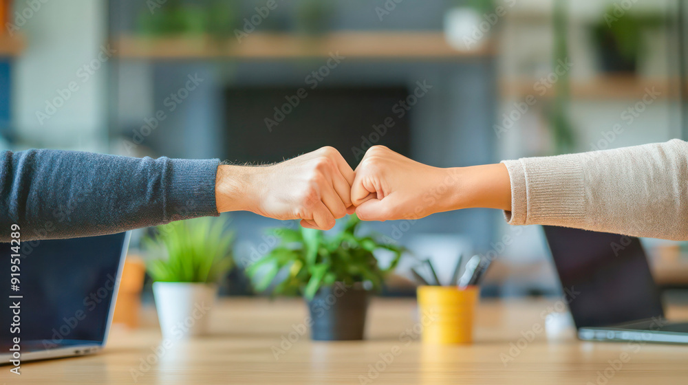 hands coming together for a fist bump over a desk in an office setting. Generative AI hands coming together for a fist bump over a desk in an office setting. Generative AI
