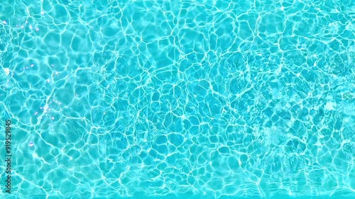 Blue water in the swimming pool with light reflections. Slow motion