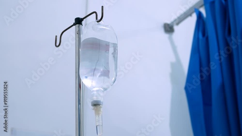 close up view of saline IV drip bag and Infusion pump hanging on stainless pole in the patient room at the hospital