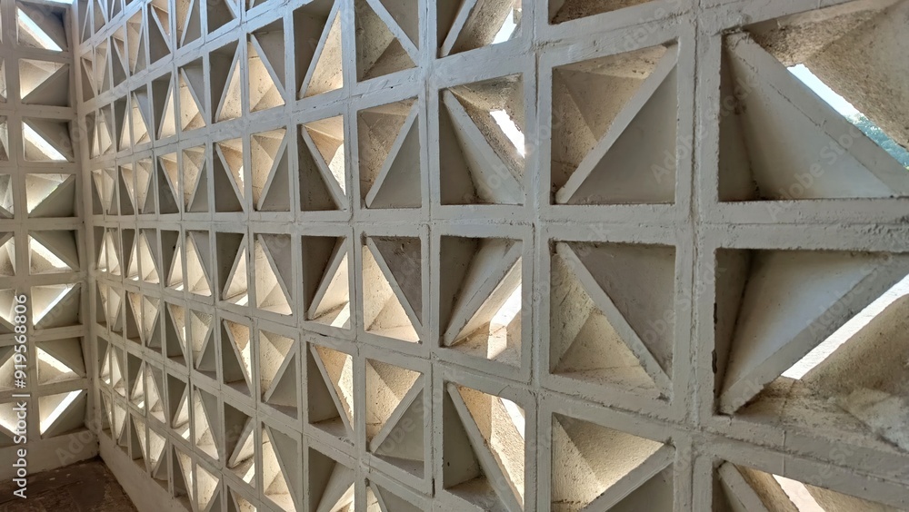 A wall made of white blocks with a lot of holes in it A wall made of white blocks with a lot of holes in it