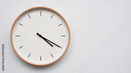 Minimalist wooden Wall Clock on White Wooden Surface with Space for Text – Time Set at 16.20/04.20