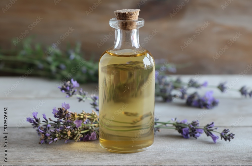 Small glass bottle containing lavender essential oil on wooden background Small glass bottle containing lavender essential oil on wooden background