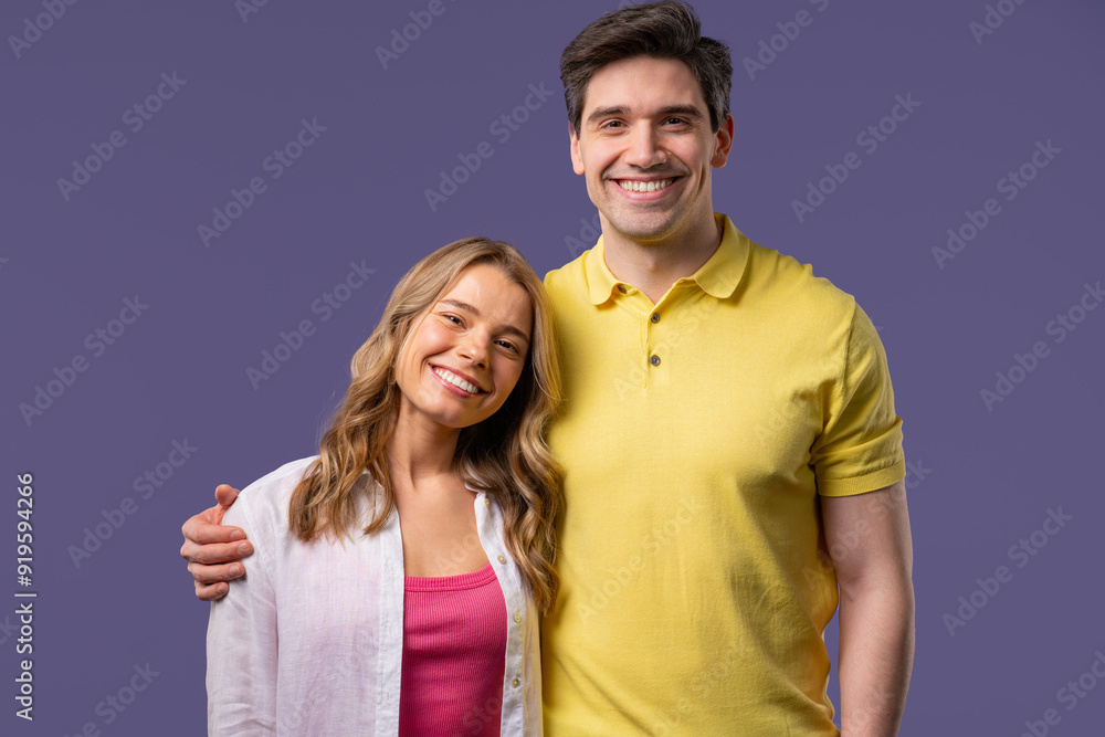 Pretty woman young adult man portrait on violet studio backdrop. Couple smiling. Pretty woman young adult man portrait on violet studio backdrop. Couple smiling.